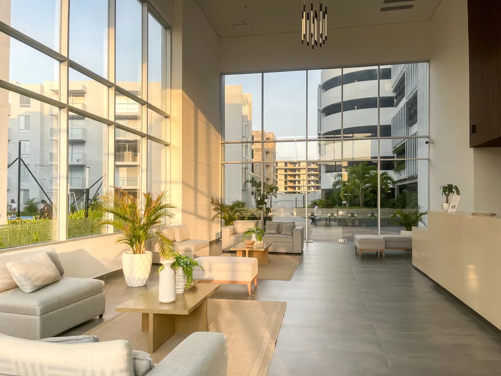 Sala social del lobby de doble altura con ventanales hacia las zonas comunes