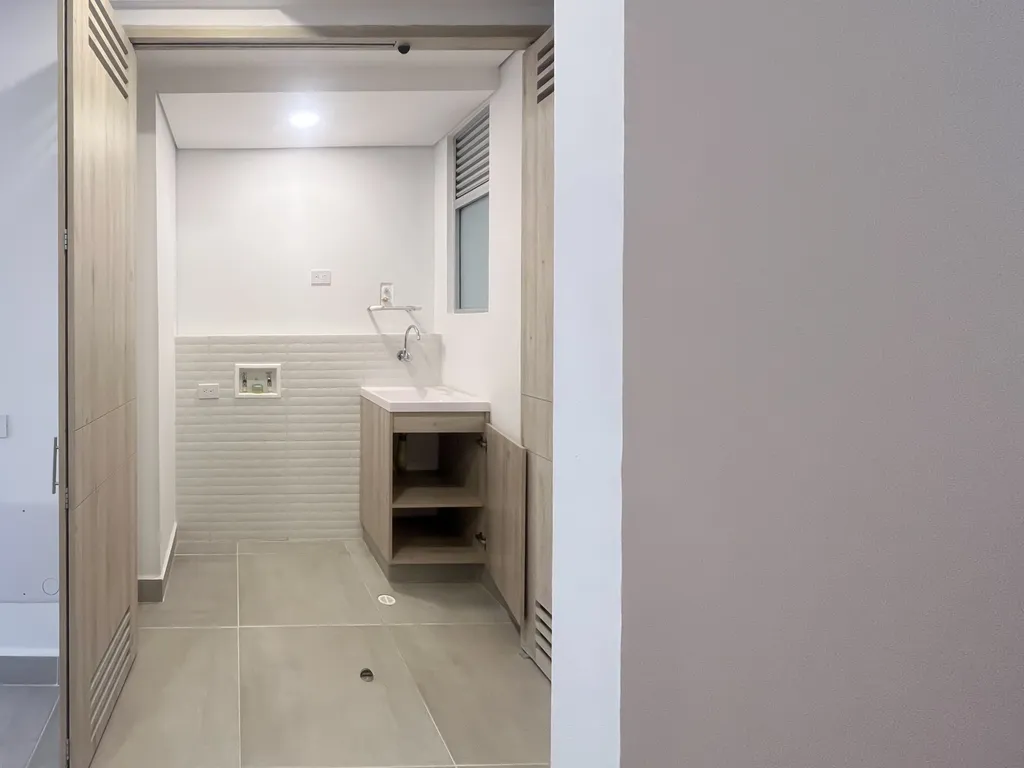 Zona de ropas independiente con lavadero y mueble en madera