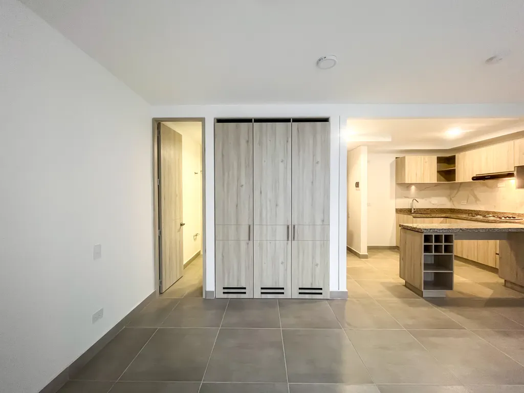 Zona íntima con clóset empotrado en madera y acceso al baño